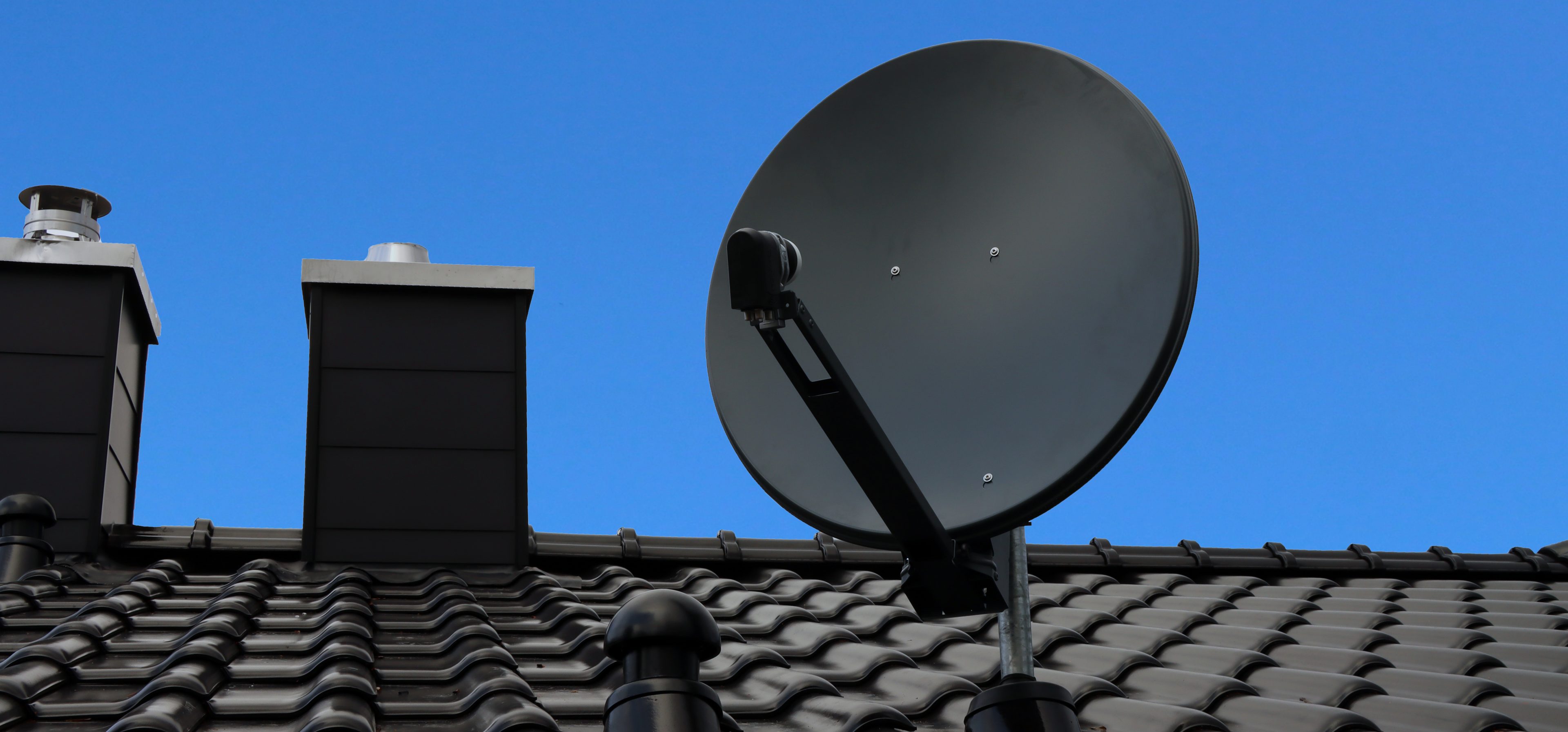 Satellitenanlage auf Dach mit blauem Himmel